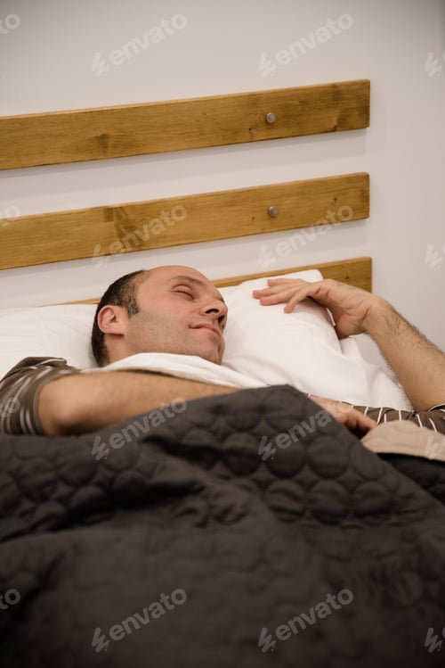 Preview: Man Holding A Pillow With His Eyes Closed As He Lays On His Side Sleeping