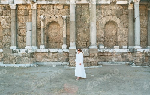 Preview: A Middle-Aged Woman In A Long White Dress Among Ancient Ruins In Sun Rays In The Center Of The Old