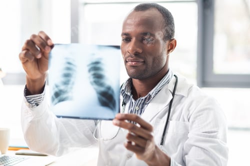 Preview: Roentgen Picture. Delighted International Practitioner Holding Plastic Picture In Hands While Doing