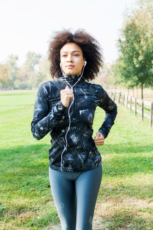 Preview: Smiling African Woman Jogging And Listening At The Music In Nature On Summer Day
