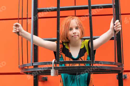 Preview: A Little Girl On The Stairs Outside, Standing In A Colored Dress Near The Orange Wall