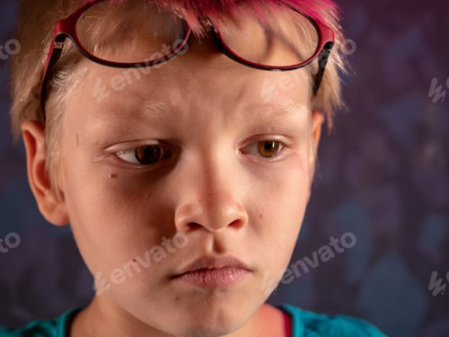 Preview: Cute Blond Child In Blue T-Shirt And Glasses Posing In Front Of Camera And Smiling