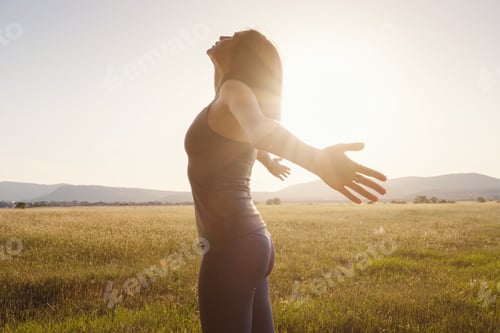 Preview: Young Girl Spreading Hands With Joy And Inspiration Facing The Sun. She Is Enjoying Serene Nature