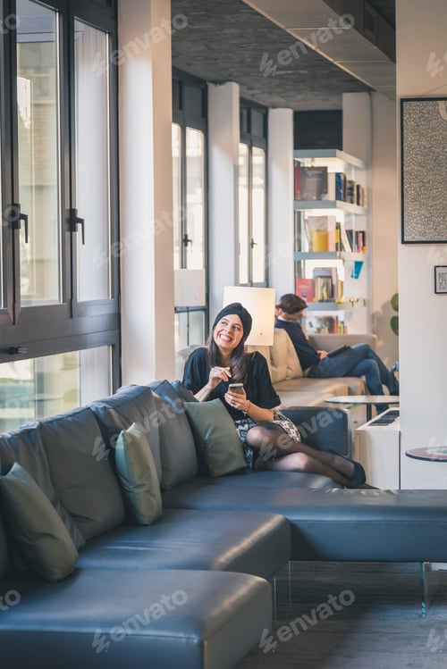 Preview: Beautiful Young Brunette With Turban Texting On A Couch