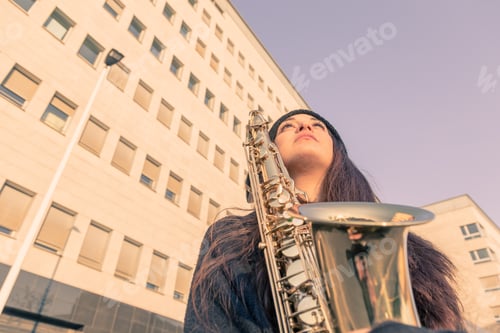 Preview: Beautiful Young Woman Posing In The City Streets With Her Saxophone