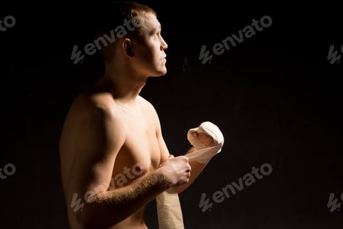 Preview: Young Boxer Motivating Himself Mentally Before A Fight As He Sits In The Darkness Applying A