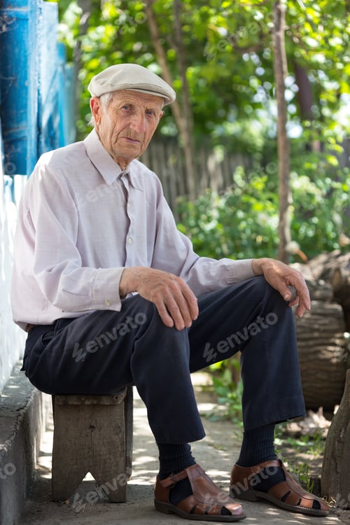 Preview: Portrait Of Senior Man Sitting Near His House In The Village