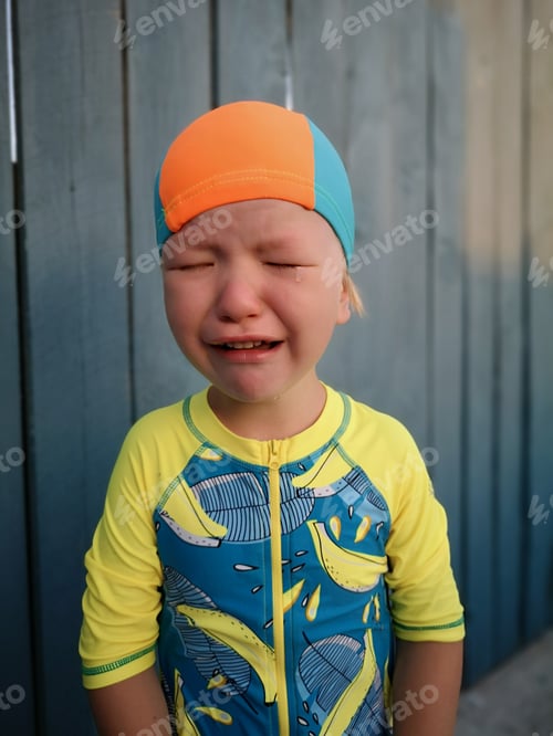 Preview: Blond-Haired Boy In Bathing Suit Cries With Tears. Child Upset