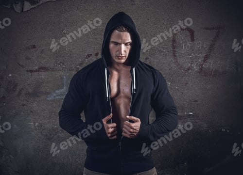 Preview: Epic Muscular Young Man - Fighter Wearing Hooded Sweater And Showing His Breast Muscle, Copyspace