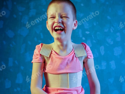 Preview: Kid In Corrector For Spine In Pink T-Shirt On A Gray Background Child Wearing Back Support Belt For