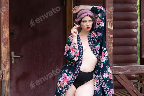 Preview: Portrait Of A Young Beautiful Village Girl Standing On The Porch And Smoking