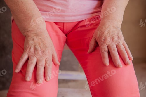 Preview: Hands Of Elderly Woman In Pink T-Shirt. Pensioner Supports Health And Looks Great