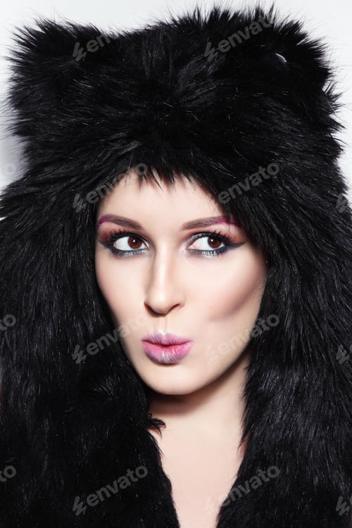 Preview: Young Beautiful Girl With Stylish Make-Up And Surprised Expression In Funky Animal Like Fur Hat
