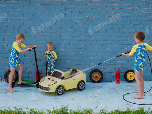 Preview: Funny Children In Boys' Bathing Suits Posing In Front Of Camera With High-Pressure Car Wash And Toy