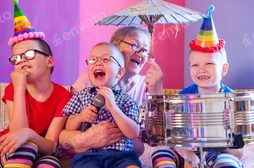 Preview: Elderly Woman In Pink T-Shirt And Glasses Holding Megaphone. Next To Grandmother, Grandchildren In