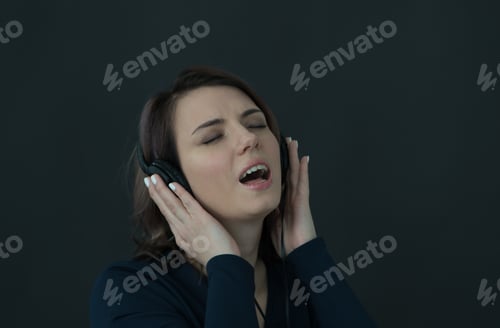 Preview: Portrait Of A Young Beautiful Girl On A Black Background With Headphones
