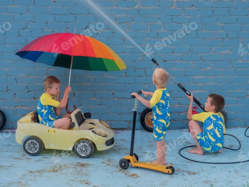 Preview: Funny Children In Boys' Bathing Suits Posing In Front Of Camera With High-Pressure Car Wash And Toy