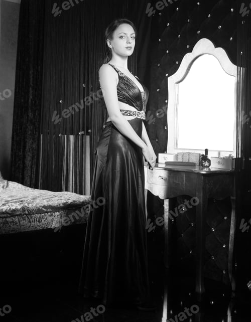 Preview: Woman In Long Dress Standing Inside Her Room, Looking At Camera. Captured In Monochrome Style.