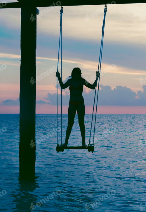 Preview: Silhouette Teen Girl On A Swing In The Sea At Sunset In The Maldives, The Concept Of Travel And The