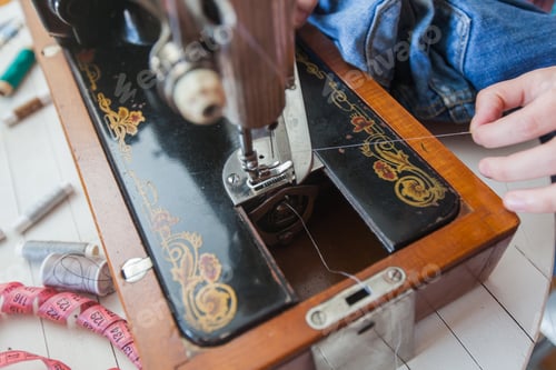 Preview: Closeup Of Female Tailor Hands Changing Thread On Old Sewing Machine At Home