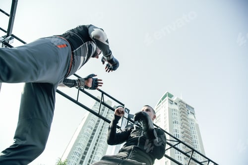 Preview: Concentrated Young Boxer Standing In Front Of His Trainer And Putting Fists Up While Mastering