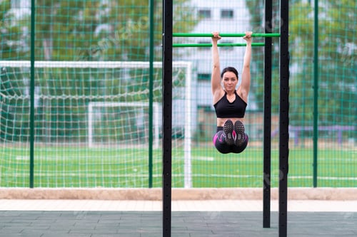 Preview: Fit Toned Young Woman Working Out On Parallel Bars At An Outdoor Sports Facility In Town In A
