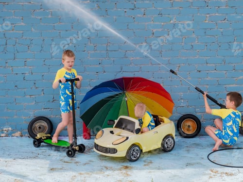 Preview: Funny Children In Boys' Bathing Suits Posing In Front Of Camera With High-Pressure Car Wash And Toy