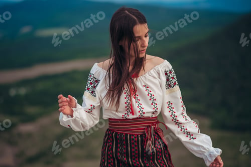 Preview: Attractive Woman In Traditional Romanian Costume On Mountain Green Blurred Background. Outdoor