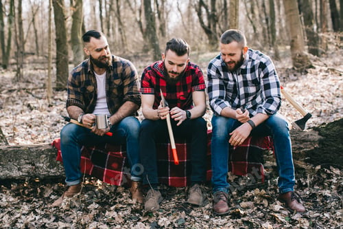 Preview: Three Bearded Men Smoke, Drink Coffee And Relax After Work In The Forest