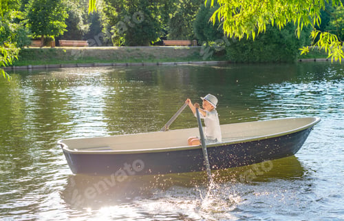 Preview: Boy Rowing A Boat On A Quiet River In. Calm And Relax. Sun Rays.