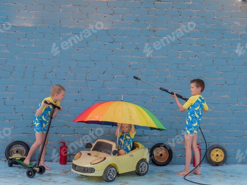 Preview: Funny Children In Boys' Bathing Suits Posing In Front Of Camera With High-Pressure Car Wash And Toy