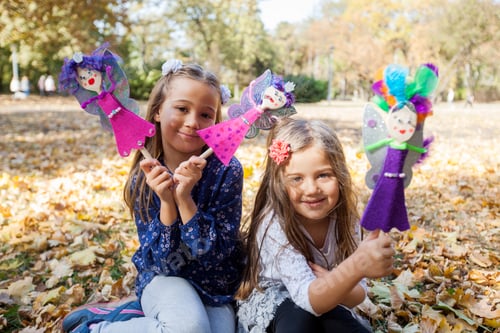 Preview: Happy Little Girls Playing With Handmade Dolls At Autumn Day In The City Park.