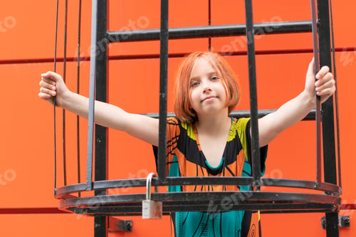Preview: A Little Girl On The Stairs Outside, Standing In A Colored Dress Near The Orange Wall