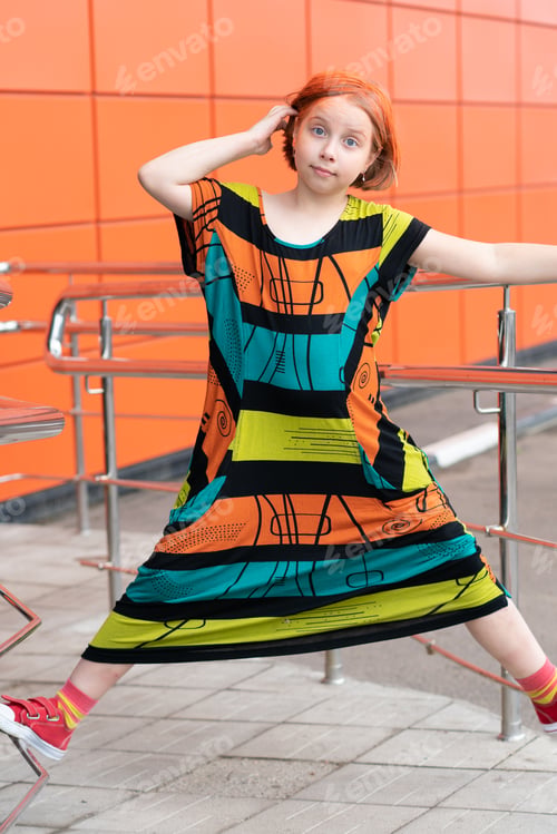 Preview: Small Girl Outside In The City Is In A Colored Dress