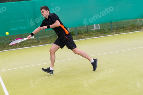 Preview: Young Man Playing Tennis Wearing A Sportswear And Outdoor On Tennis Grass Court At Early Morning