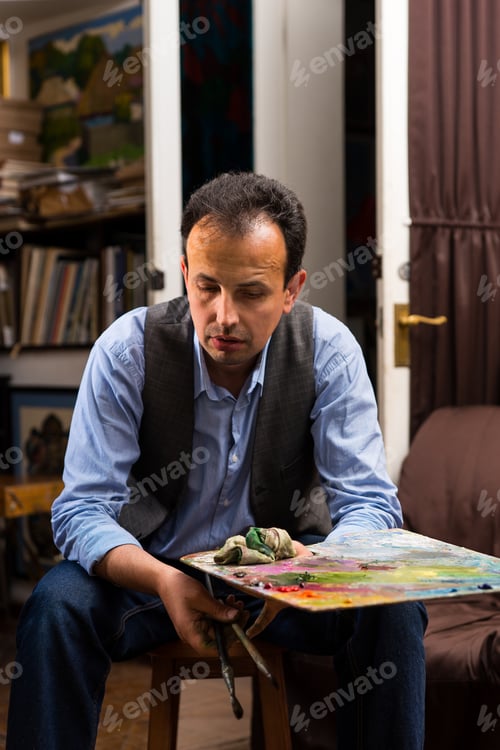 Preview: Male Painter Holding A Colorful Artists Palette And Paintbrush In His Hand In A Studio