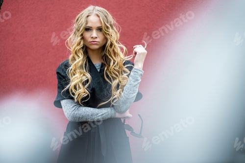 Preview: Portrait Of Happy Beautiful Blonde Woman With Long Sexy Healthy Hair On Red Background. Urban