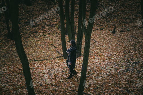 Preview: Charming Lady With Dreadlocks Wearing Black Mantle Standing By The Old Tree In The Autumn Forest