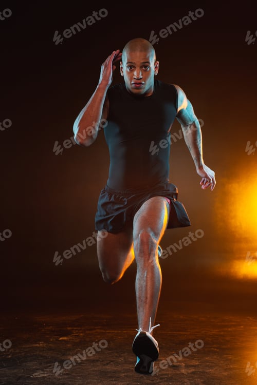 Preview: Hardworking Professional Sportsman In T-Shirt And Shorts Running Extremely Fast With Orange Light