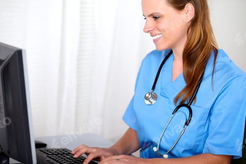 Preview: Portrait Of A Blonde Friendly Young Nurse Looking To Computer Screen At Hospital