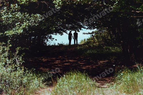 Preview: Silhouette Of A Loving Couple On A Background Of Clouds. Shot Of Two Hikers Standing On Top Of A