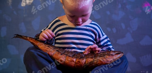 Preview: Little Blond Boy Shows Big Smoked Fish. Child Wants To Catch Big Fish In Ariver. Concept Of Organic