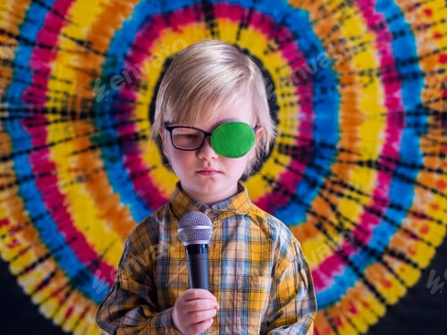 Preview: Portrait Of Funny Child In New Glasses With Green Spot To Correct Strabismus And Microphone