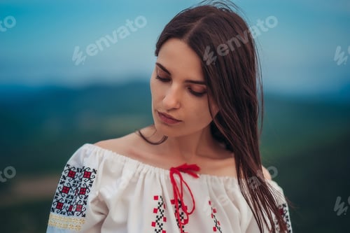 Preview: Attractive Woman In Traditional Romanian Costume On Mountain Green Blurred Background. Outdoor