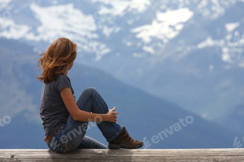 Preview: Girl Hiker Sitting And Looking At The Snowed Mountains