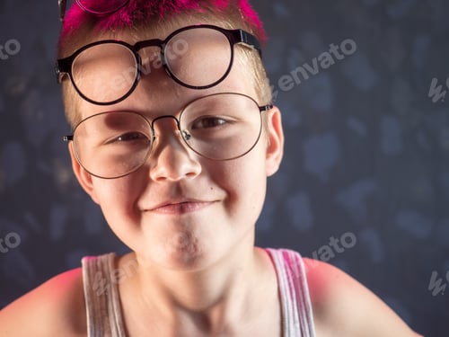 Preview: Photo Of Funny Boy, Blonde Kid With Lot Of Pairs Of Glasses On His Face. Child Is Happy At Home On
