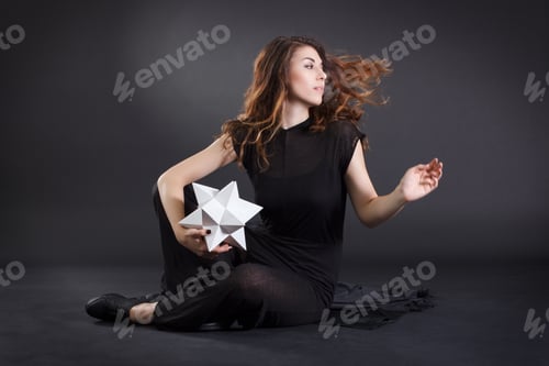 Preview: Fashion Woman With Developing Hair And Paper Polygon In Hand.