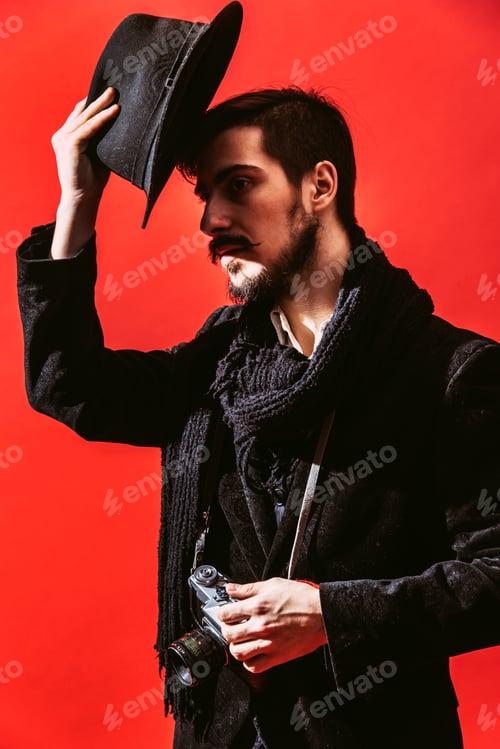 Kreativer Fotograf posiert im Studio mit Kamera in der Hand