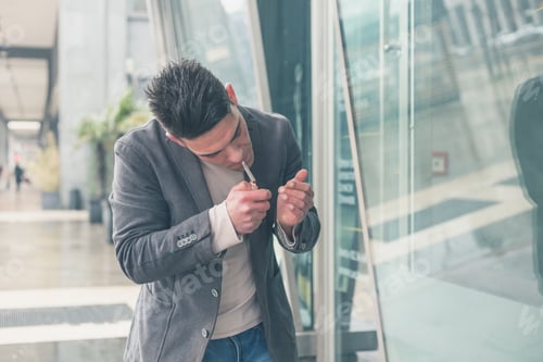 Preview: Young Handsome Man With Short Hair Smoking A Cigarette In The City Streets