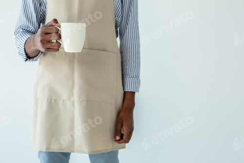 Preview: Have A Drink. Pleasant Professional Barista Holding Cup Of Coffee Against White Background